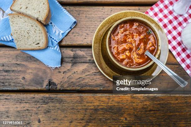 top view of a tripe soup served with bread on a wooden table. - tripe stock pictures, royalty-free photos & images