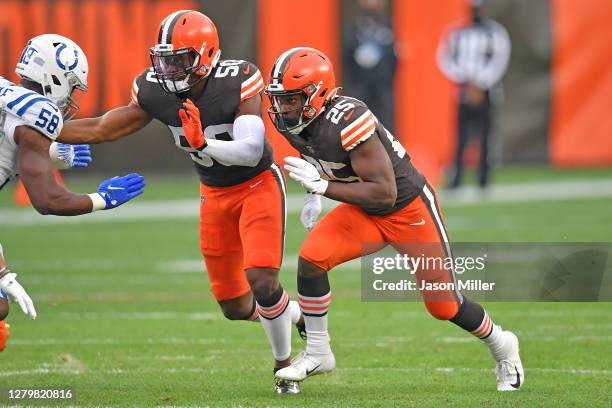 Linebacker Jacob Phillips and running back Dontrell Hilliard of the Cleveland Browns try to block inside linebacker Bobby Okereke of the Indianapolis...