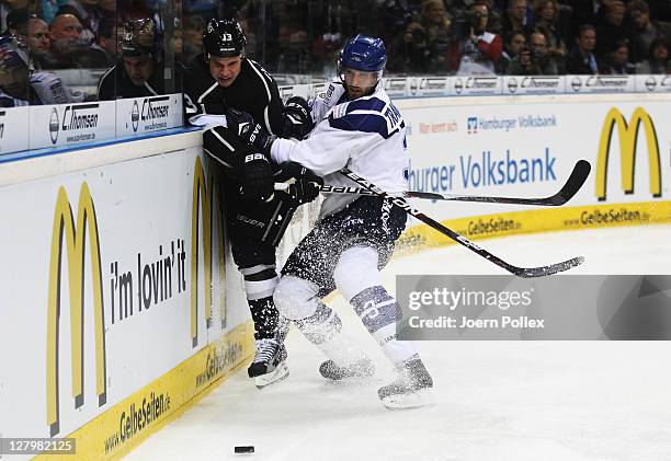 Patrick Traverse of Hamburg boards Kyle Clifford of Los Angeles during the NHL Pre-Season game between Hamburg Freezers and Los Angeles Kings at the...