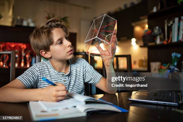 little boy doing geometry homework in the evening - workbook stock pictures, royalty-free photos & images