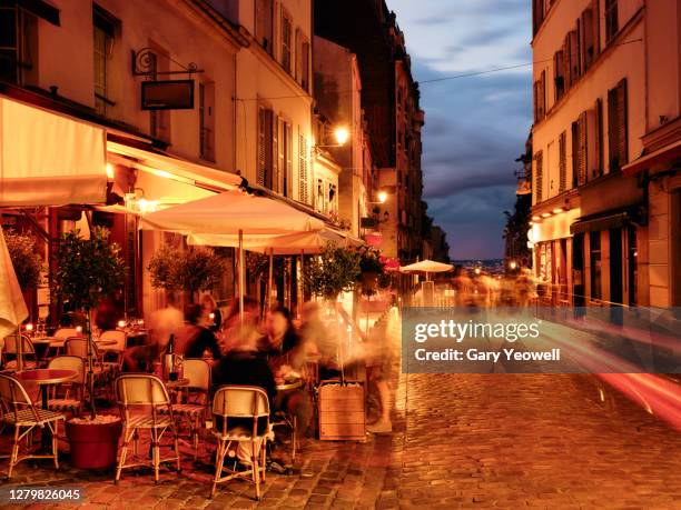 busy paris street lined with bars and restaurants - street restaurant stockfoto's en -beelden