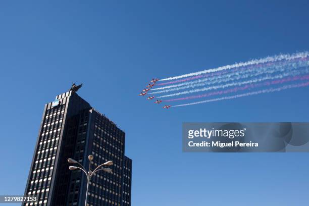 Spanish Air Force fighters of the renowned Patrulla Águila fly over the Mutua Madriea headquarters building on Paseo de la Castellana during the...
