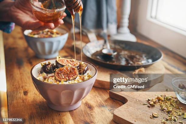 preparing yogurt with caramelized figs, pistachio and honey - tart dessert stock pictures, royalty-free photos & images