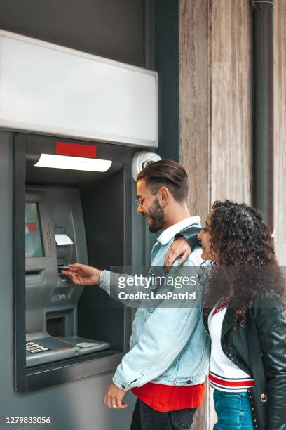 young couple withdrawal money from a bank atm - girlfriend stock pictures, royalty-free photos & images