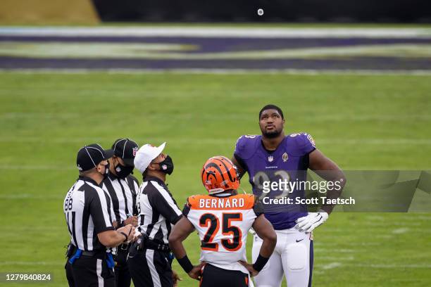 Calais Campbell of the Baltimore Ravens and Giovani Bernard of the Cincinnati Bengals participate in the coin toss before the game at M&T Bank...