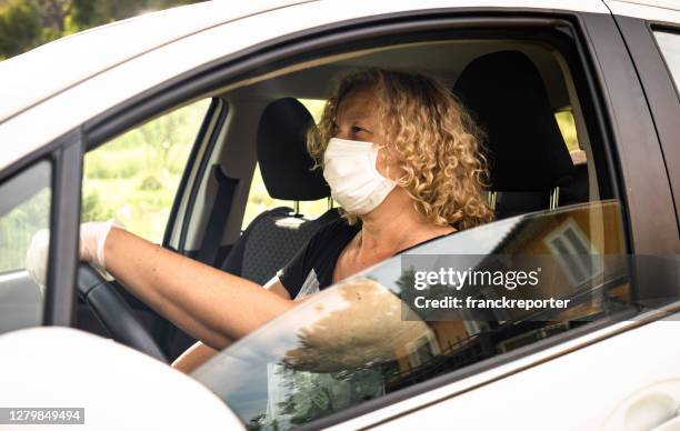 woman driving with car with face mask - coronavirus punishment stock pictures, royalty-free photos & images