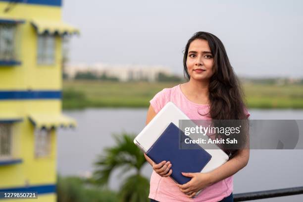 微笑的年輕女大學生與書和筆記型電腦。 - indian college girl 個照片及圖片檔