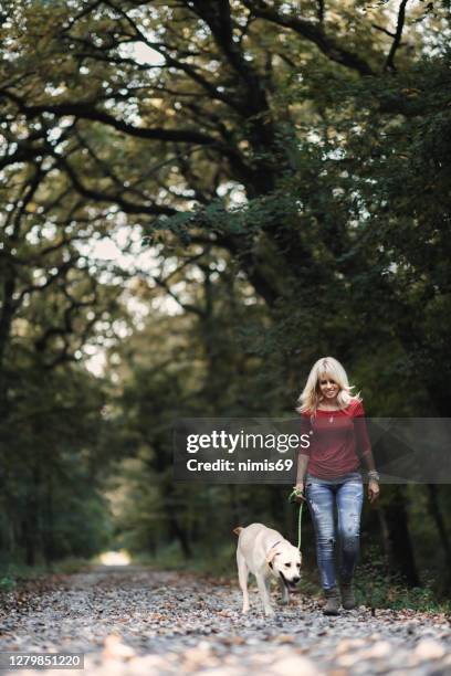 haar hond maakt haar gelukkig - happy lady walking dog stockfoto's en -beelden