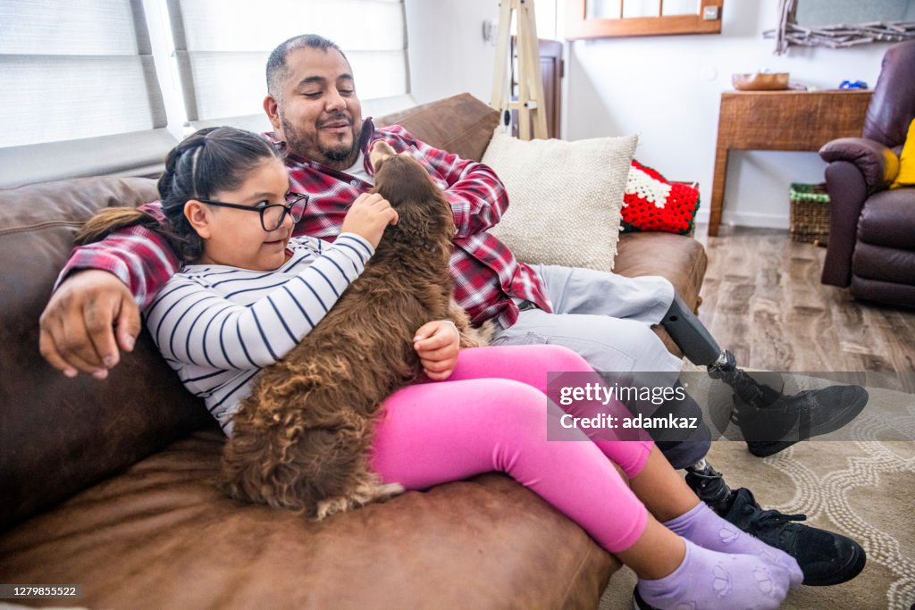 Disabled Father and Daughter playing with Long Haired Dachshund Dog