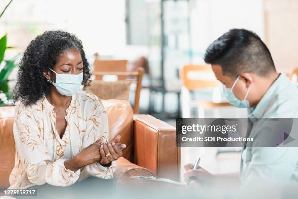 vulnerable woman talks with mental health professional - businesswoman mask stock pictures, royalty-free photos & images