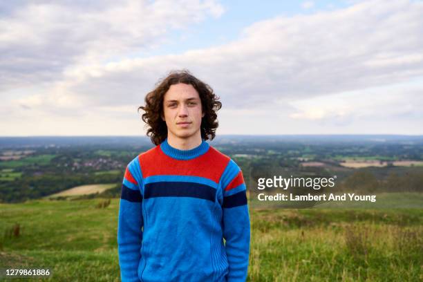 young man with bright sweater looking serious in the outdoors - jeunes hommes photos et images de collection