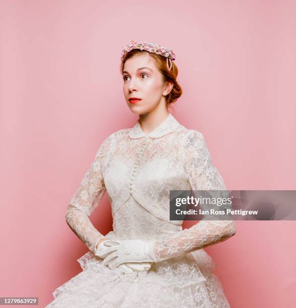 retro-styled elegant woman in white dress and flowered hat - lace dress stock-fotos und bilder