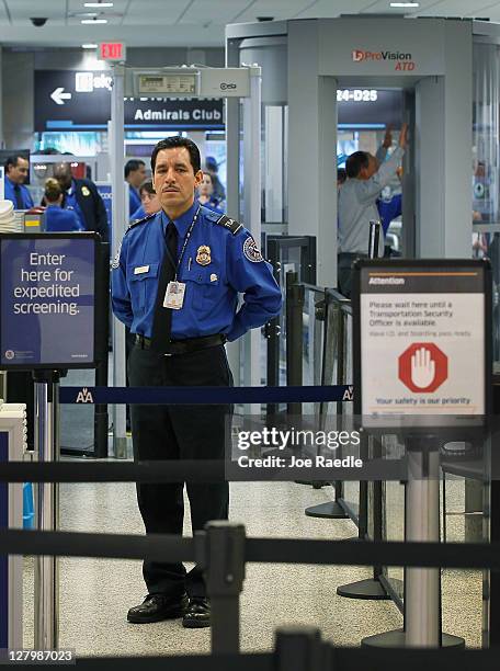 Agent waits for passengers to use the TSA PreCheck lane being implemented by the Transportation Security Administration at Miami International...