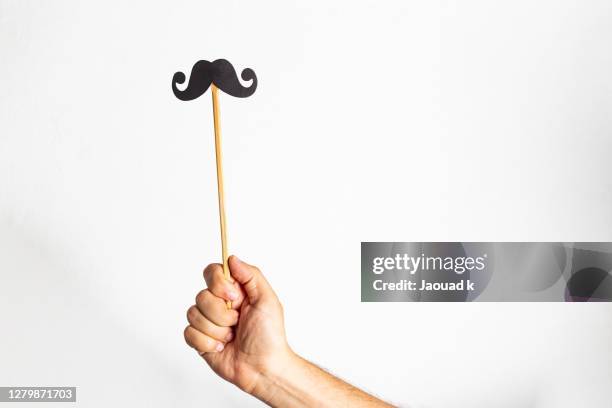 hand holding a mustache photo booth props - photo booth vintage photos et images de collection