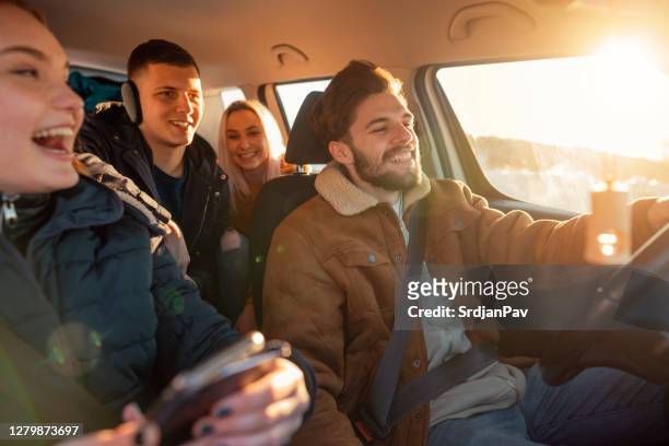 lächelnd, junge leute auf einer bergstraße - auto winter stock-fotos und bilder