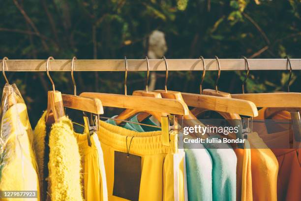 clothes hang on a shelf in a designer clothes store - green dress 個照片及圖片檔