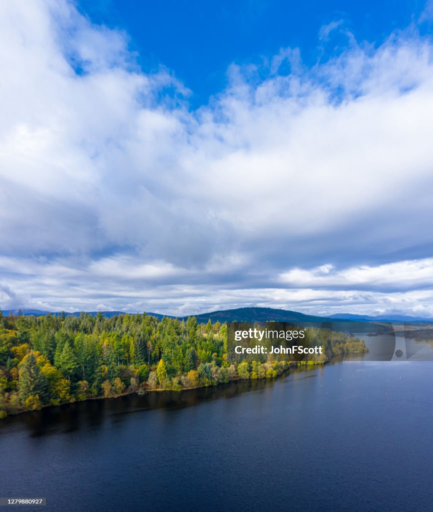 The aerial view of a slow moving river and forest in rural Dumfries and Galloway south west Scotland