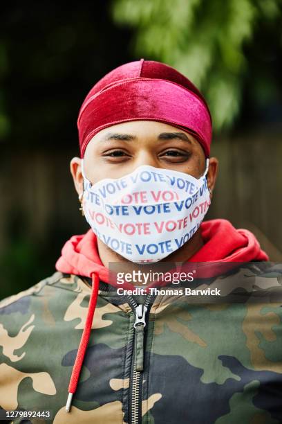 portrait of man wearing protective face mask that says vote - voting mask stock pictures, royalty-free photos & images