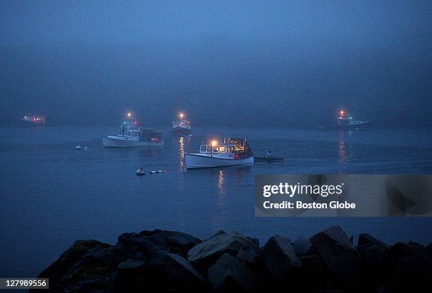 Lobster boats wait in the early morning light before heading out to lay some of their traps on trap day. The lobstermen will make several trips out.