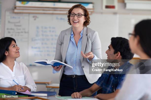 professor gesturing while explaining to diverse multi-cultural students - puberty changes stock pictures, royalty-free photos & images