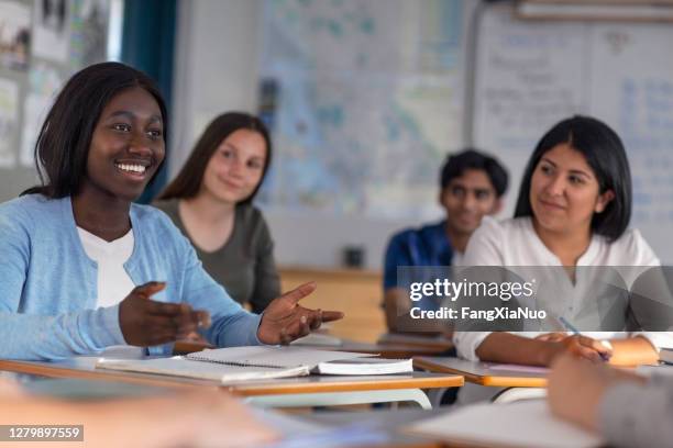 estudiante de etnia negra sonriendo gesting mientras habla en clase - social history fotografías e imágenes de stock