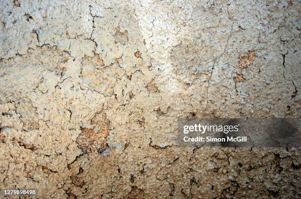 cracked and peeling beige paint on an old weathered stucco wall - condemn stock pictures, royalty-free photos & images