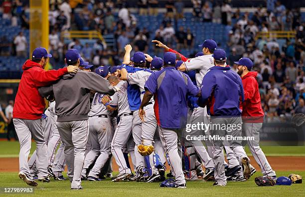 Closer Neftali Feliz of the Texas Rangers celebrates with catcher Mike Napoli and the rest of their teammates after the Rangers defeat the Tampa Bay...