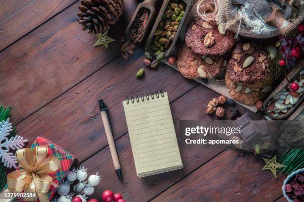 ingredients for chocolate and nuts cookie making with frame and note pad for whish list. christmas themes. - wish list stock pictures, royalty-free photos & images