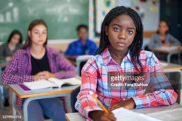 portrait of concerned black ethnicity student concentrating in classroom - stereotypical stock pictures, royalty-free photos & images