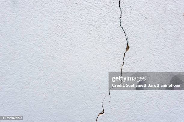 earthquake cracking on white plaster wall background, cement texture and copy space. - cracked plaster stock pictures, royalty-free photos & images