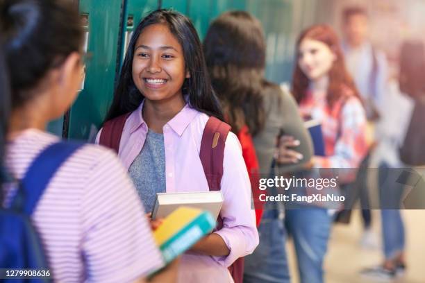 学校の廊下で話している10代の学生と陽気なアジアの女の子 - 中学校 ストックフォトと画像