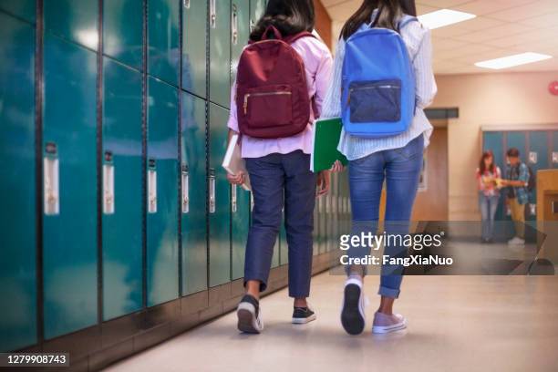 amiche compagne di classe con zaini che camminano negli armadietti a scuola - locker foto e immagini stock