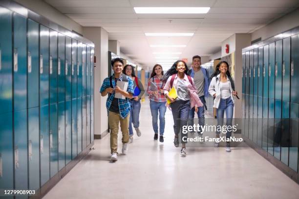 diverse multi-etnische tienerstudenten die in gang op school lopen - arriving late class stockfoto's en -beelden