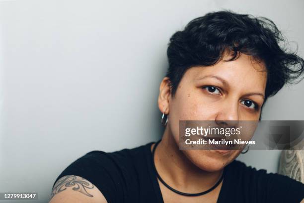 androgynous latinx woman smiling - vulnerability stock pictures, royalty-free photos & images