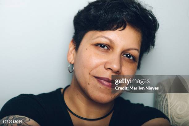 mujer latina andrógino sonriendo - hoop earring fotografías e imágenes de stock