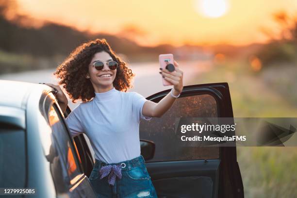 teenager girl taking selfie out of the car - car selfie stock pictures, royalty-free photos & images