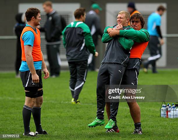 Prop Tony Buckley picks up teammate Keith Earls as Donnacha Ryan looks on during an Ireland IRB teammate Rugby World Cup 2011 training session at...