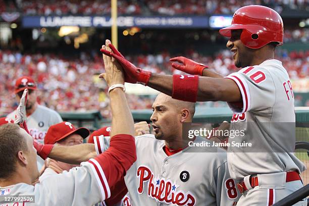 Ben Francisco of the Philadelphia Phillies celebrates in the dugout with teammates after hitting a three-run home run against the St. Louis Cardinals...