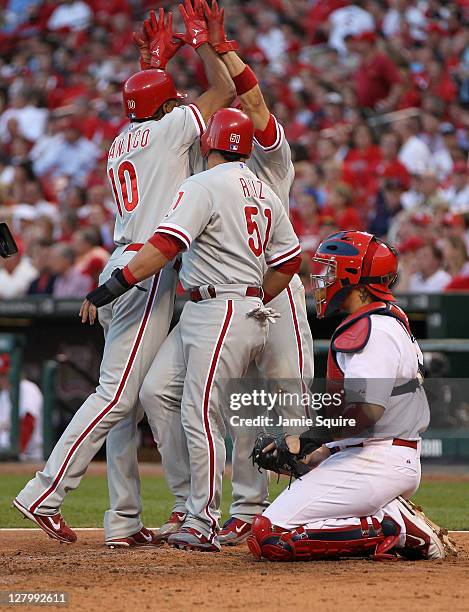 Carlos Ruiz, Shane Victorino and Ben Francisco of the Philadelphia Phillies celebrates after Francisco's three-run home run against the St. Louis...