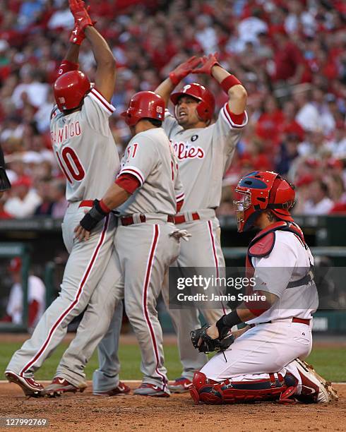 Carlos Ruiz, Shane Victorino and Ben Francisco of the Philadelphia Phillies celebrate after Francisco's three-run home run as Yadier Molina of the...