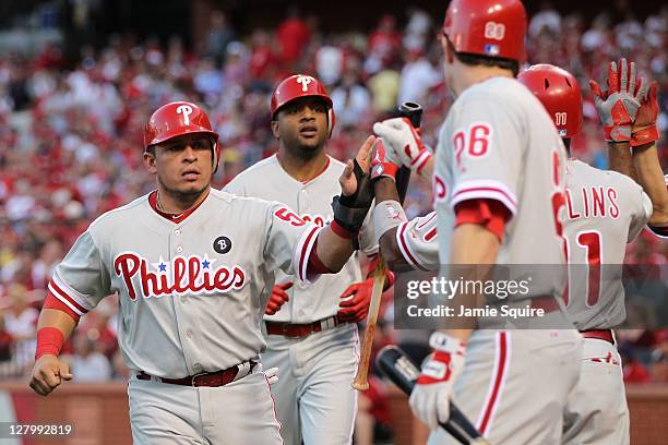 Carlos Ruiz and Ben Francisco of the Philadelphia Phillies celebrate with Chase Utley and Jimmy Rollins after Francisco's three-run home run as...