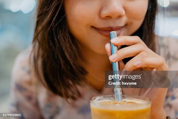 giovane donna asiatica bere caffè con paglia di metallo - straw foto e immagini stock