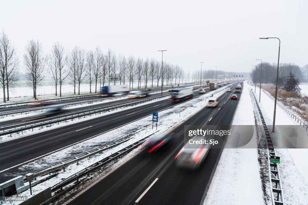 Moving traffic on a highway during a snow blizzard in winter