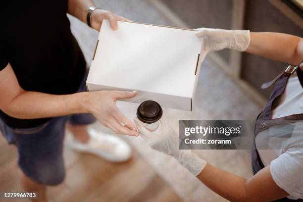 high angle view of customer's hands receiving takout order, coffee and food in the box - takeaway box stock pictures, royalty-free photos & images