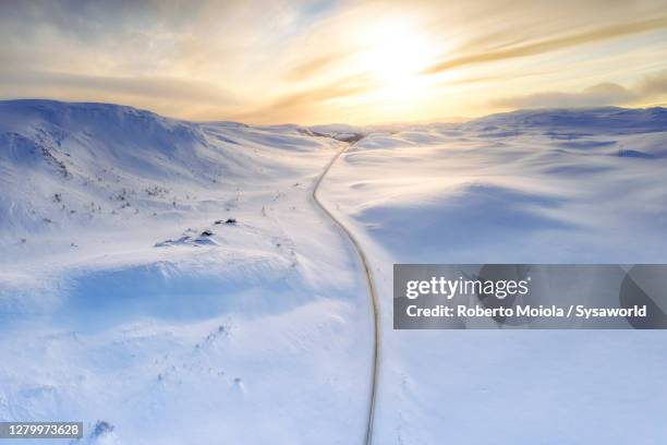 road crossing the snow capped mountain, sennalandet, finnmark, norway - alta stock-fotos und bilder