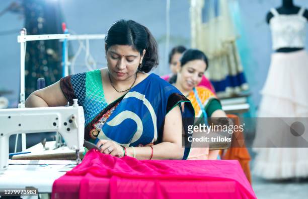 indisk kvinna textilarbetare skära klänning tyg på produktionslinje - garment factory bildbanksfoton och bilder