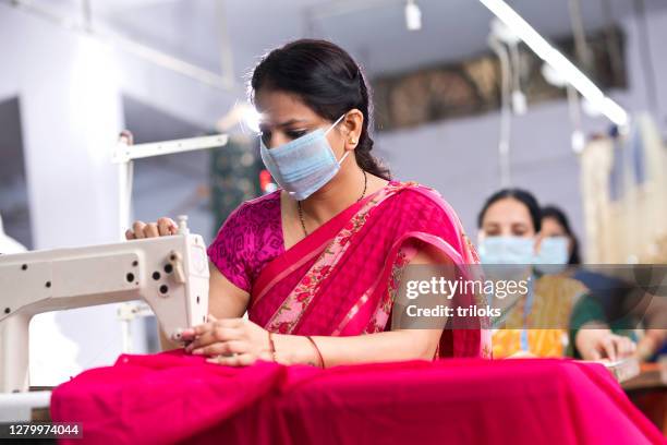 indian woman textile workers with protective face mask on production line - indian textile stock pictures, royalty-free photos & images