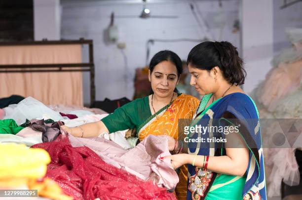 two woman textile worker checking garment stock at factory - textile industry stock pictures, royalty-free photos & images