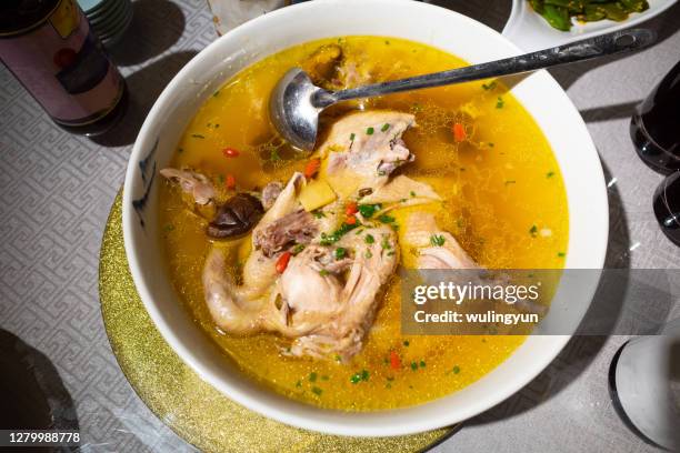 whole chicken soup served at dinner time - chicken soup stock pictures, royalty-free photos & images
