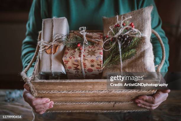 beschnittene hände arrangieren weihnachtsgeschenke in holzkiste. - christmas hampers stock-fotos und bilder